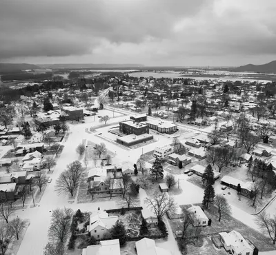 Aerial winter view of Wabasha, MN, showcasing snow-covered houses and trees.